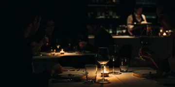 Elegant dark dining experience with silhouettes of diners