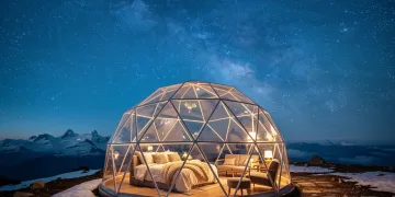 Transparent geodesic dome under a starlit high-altitude sky, offering a luxurious stargazing experience.